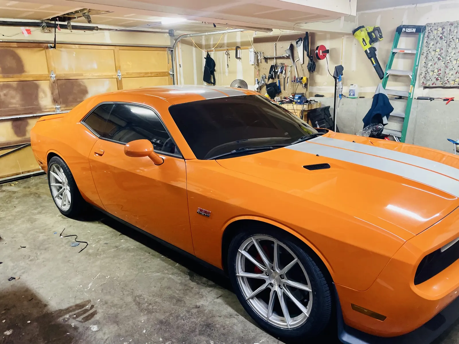 Orange Dodge Challenger with tinted windows in the garage