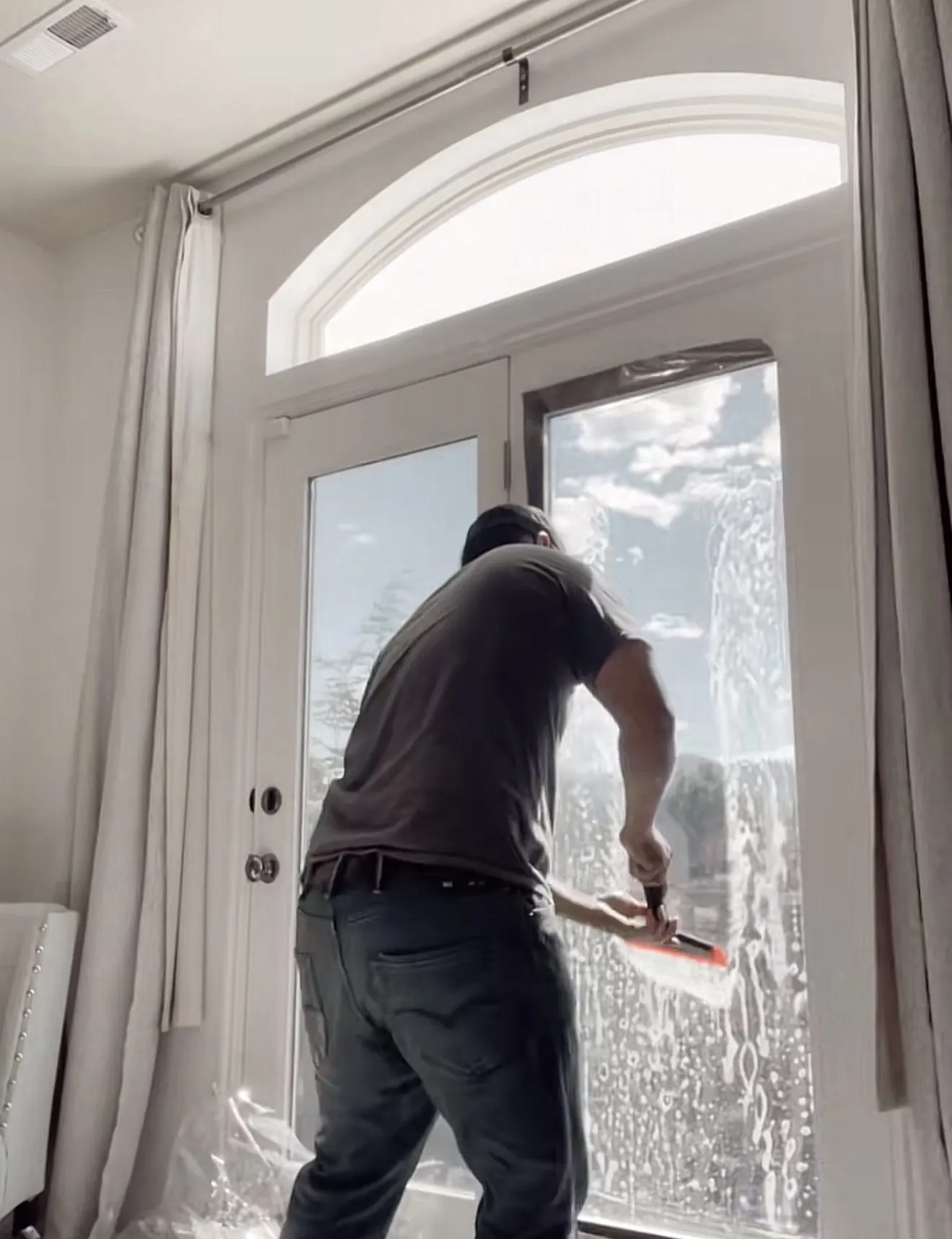 Installer applying window film to a large residential patio door