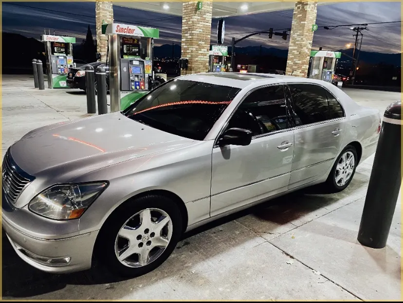 Silver Lexus sedan with tinted windows at night