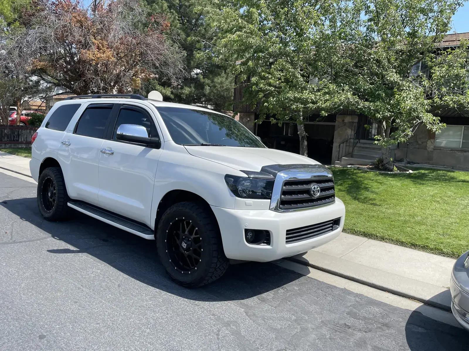 Lifted white Toyota Sequoia with fully tinted windows