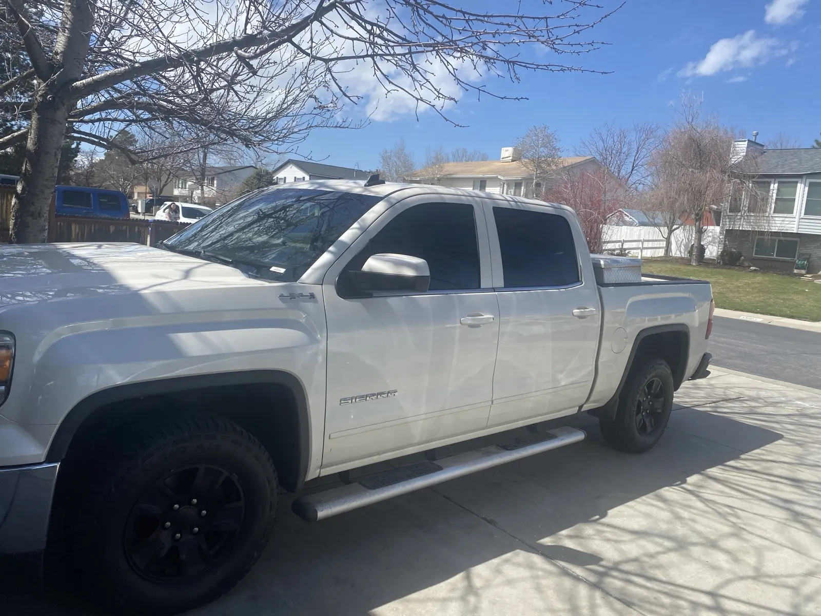White GMC Sierra crew cab truck with tinted windows