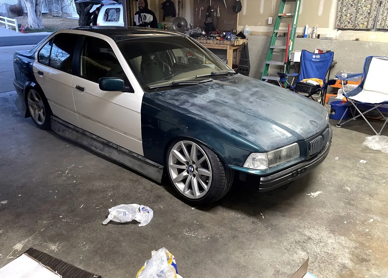 BMW 3 Series with bare primer panels before a custom color-shift wrap